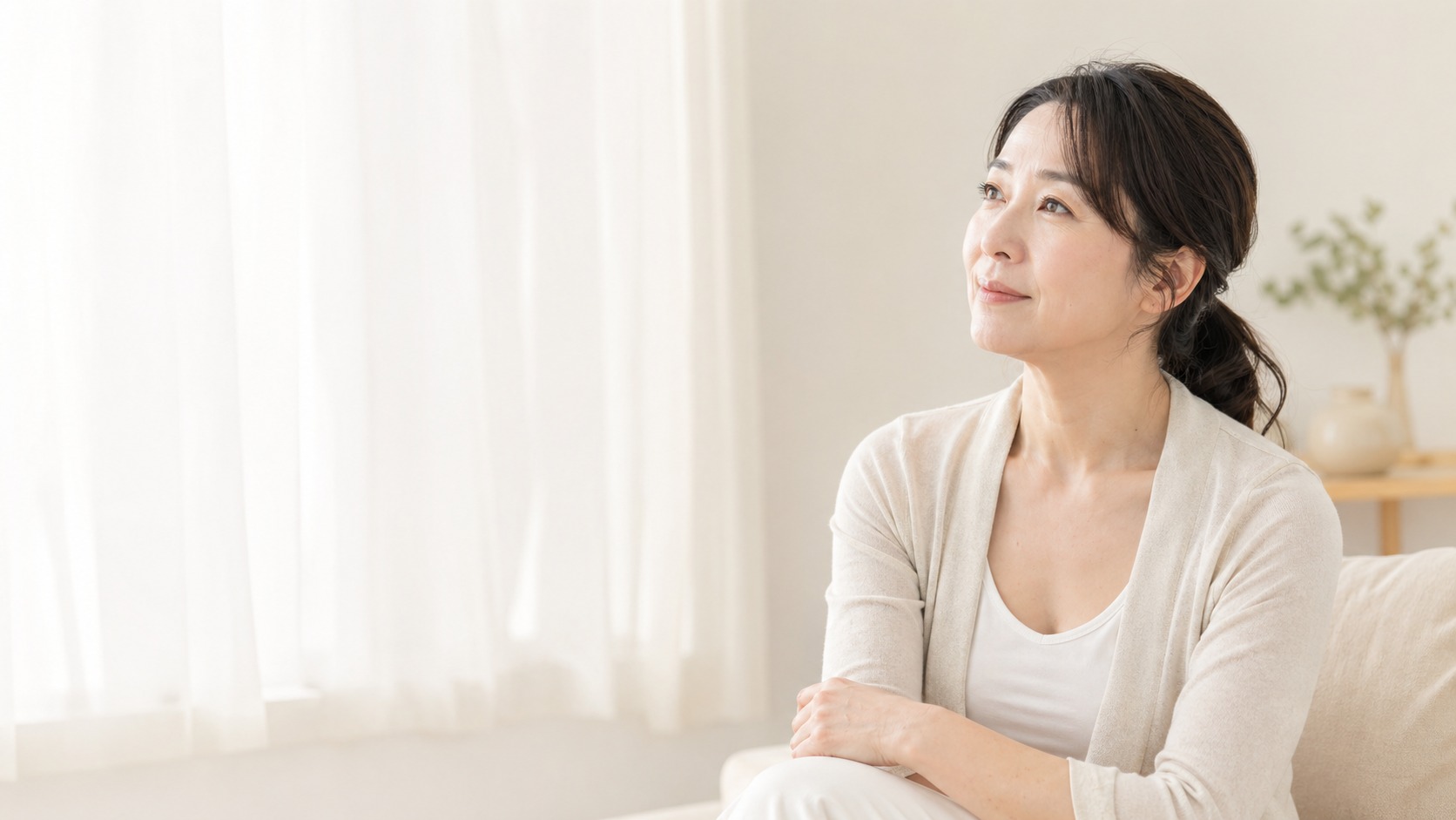 窓辺で前向きに考える女性
