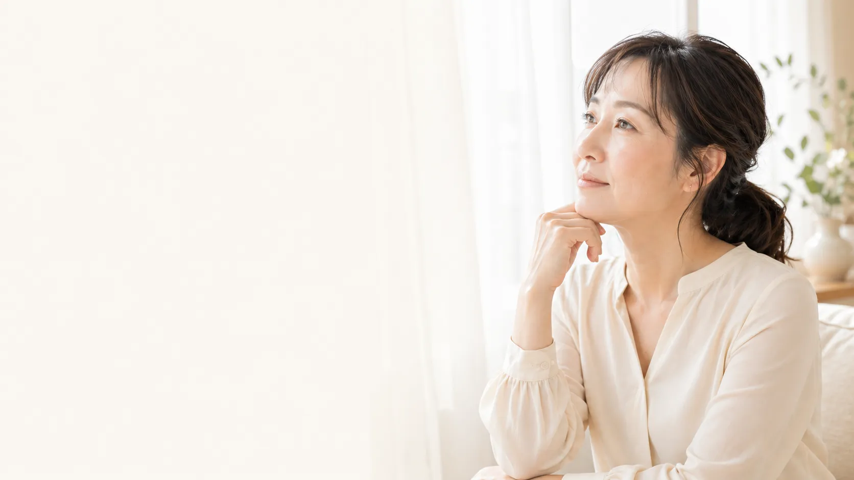 窓辺で考える40代から50代の女性